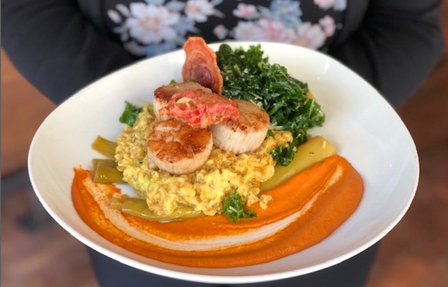 Seared scallops with farro risotto, saffron crème, almond romesco, confit leeks, kale, capers, pancetta, cauliflower & salsa vinagretta.